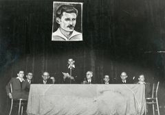 Hungary, Simha Hunwald  portrait on the wall. On the left side of the picture sits David Gur.  On the right side of the picture sits Meir-Yosko.  The speaker is Dan Levni (Anti), the secretary of Hashomer Hatzair in Budapest (he passed away in Kibbutz Ga'aton in a work accident).  The event took place at the Academy of Music in Budapest., 1949, Yuval Alpan, [object Object], [object Object], [object Object], [object Object], Dokuforte #2977