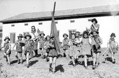 Israel, HaOgen, 'Shibolim' - the second children's group of HaOgen, with teacher Tzipi (on the left) and caretaker Nechama. Preparing for the May 1st demonstration in Tel Aviv. Related to the photo on the 'Inter' car with the children. From the right: Ruti, Micha, Yael, Nira, Amira, Uzi, Dani (behind the flag), Yoska, Tzvi.

With cooperation of Nadav Mann / Bitmuna, 1950, Dany Benshalom, Rafi Benshalom, [object Object], [object Object], [object Object], Dokuforte #3461